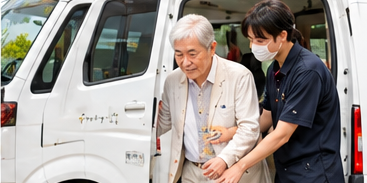 送迎車への乗り降りをスタッフがサポートする様子